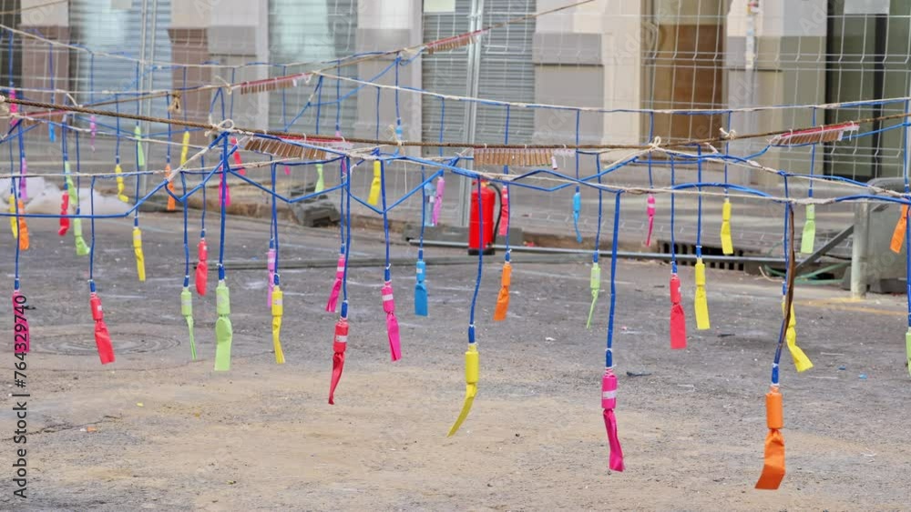 Firecrackers hanging on a thread in city street. Colorful firecrackers bouncing hanging on a thread at city street before mascleta in slow motion during Las Fallas.