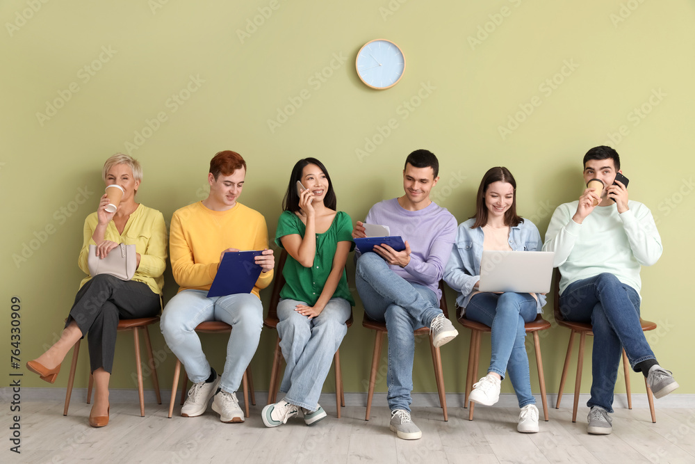 Fototapeta premium Applicants waiting for job interview near green wall in room