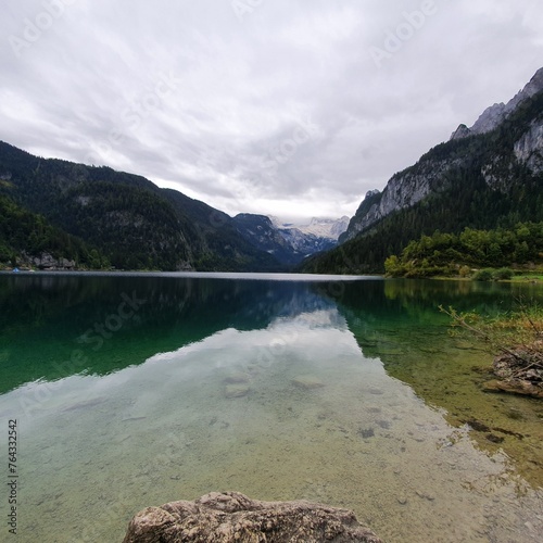 Fototapeta Naklejka Na Ścianę i Meble -  The water in the lake is like a mirror reflecting the mountains and sky. Gosaus, Austria 2022