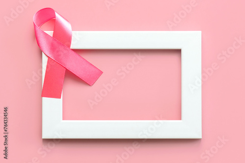Top view of pink ribbon symbol of breast cancer on a white frame with space for text. Breast cancer awareness concept