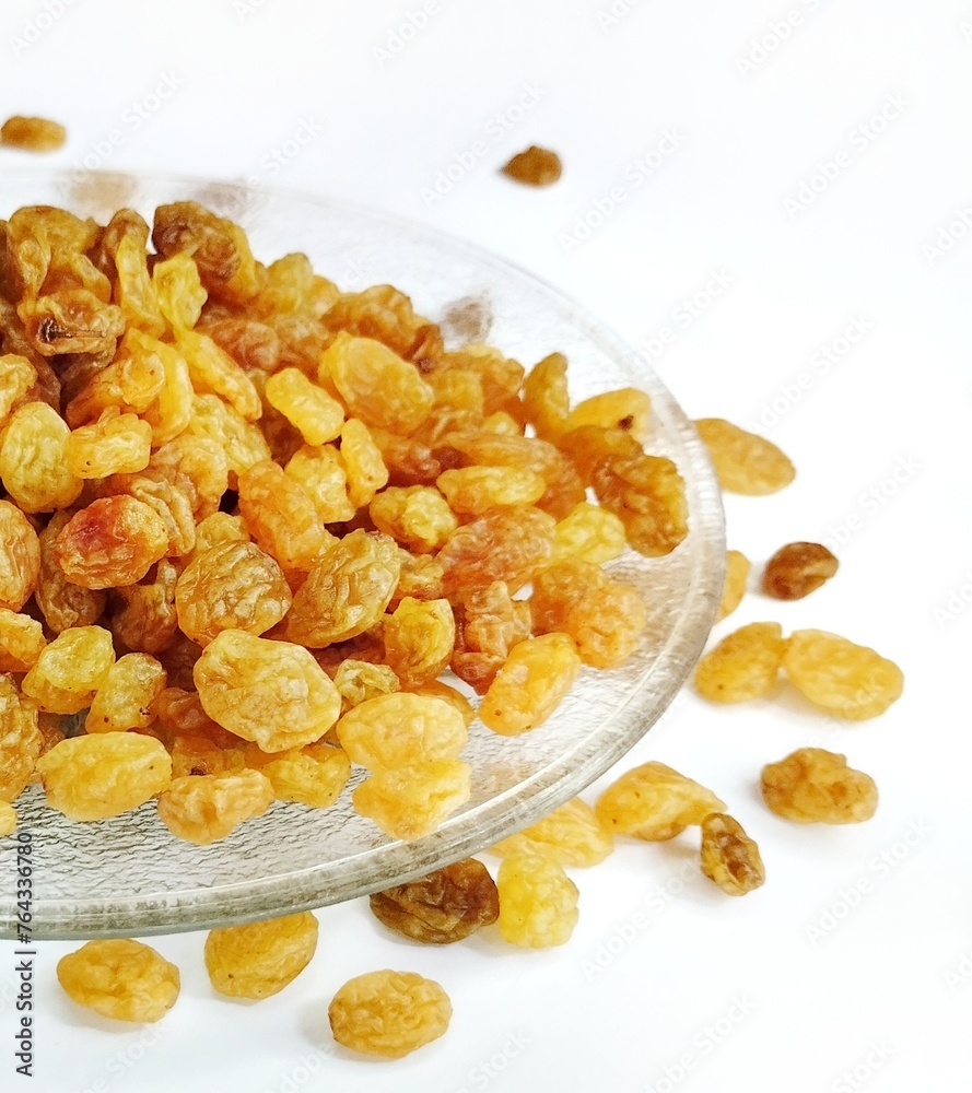 Currant fruit on a white background. Pile the dried raisins on a clear plate Currant fruit on a white background. Pile the dried raisins on a clear plate