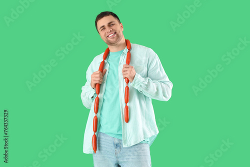 Young man with tasty sausag...
