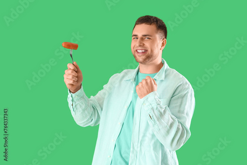 Young man with tasty sausag...