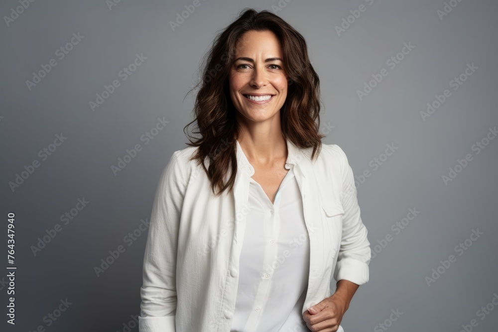 Portrait of a smiling businesswoman in white shirt over grey background Portrait of a smiling businesswoman in white shirt over grey background