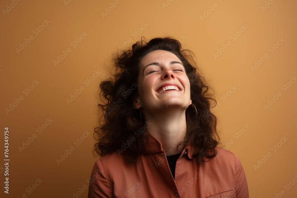 Portrait of a beautiful young woman with long curly hair laughing. Portrait of a beautiful young woman with long curly hair laughing.