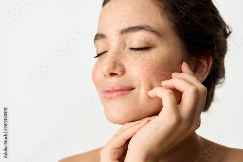 Aesthetic beauty photo of smiling young woman with freckles on face enjoying fresh clean healthy skin advertising skincare sunscreen cosmetics. Happy brunette Latin girl isolated on white background. photo