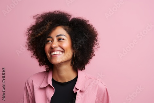 Portrait of a beautiful african american woman smiling against pink background