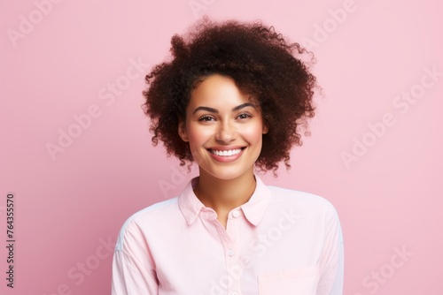 Portrait of smiling african american businesswoman on pink background