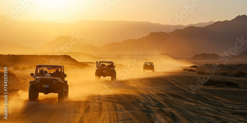 A convoy of off-road vehicles raises clouds of dust while driving through a desert landscape during a picturesque sunset.