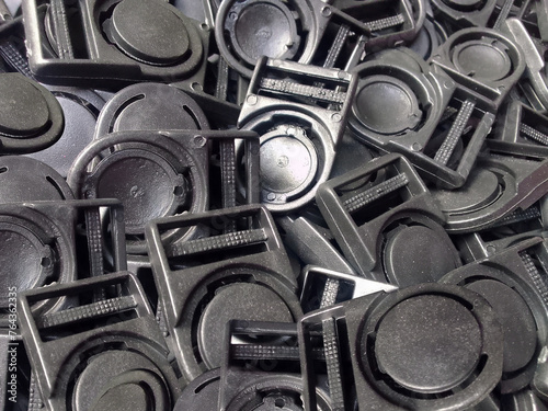 pile of black plastic hook buttons. a set of black identification card hooks or buttons. industrial plastic stopper