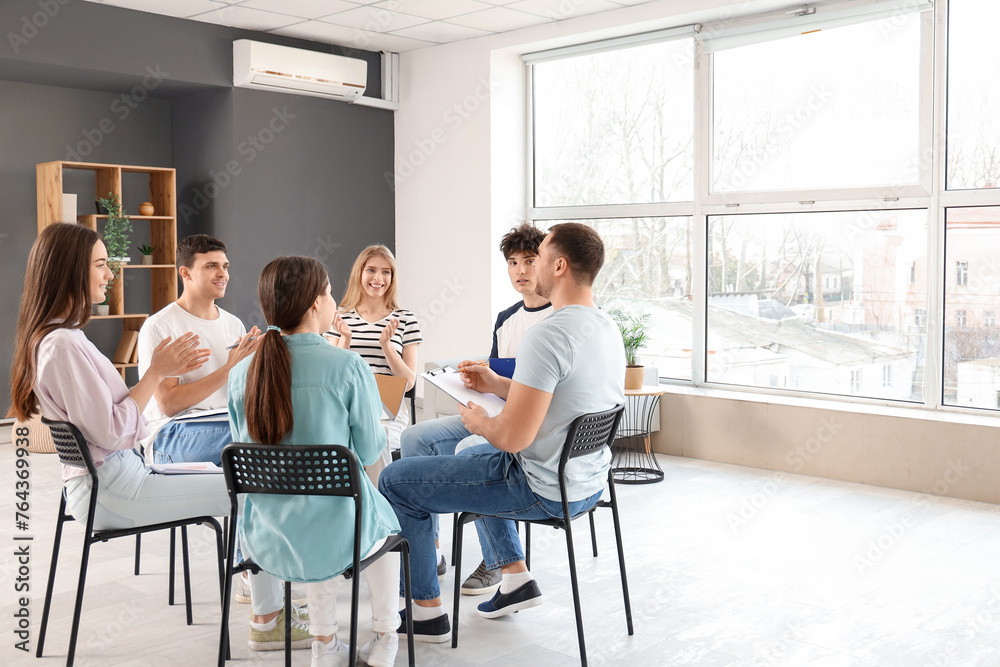 Young people clapping their hands at group therapy session