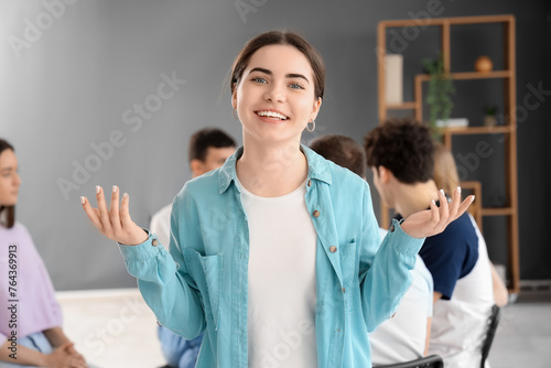 Smiling young woman at group therapy session