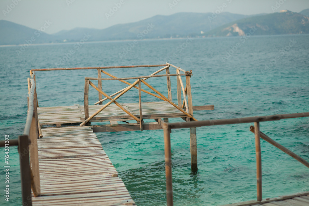 Wooden deck on ocean green water Wooden deck on ocean green water