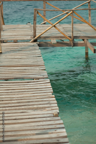 Wooden deck on ocean green water © Mohsin Khawar