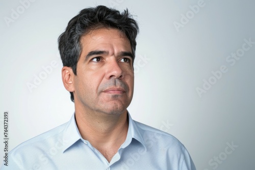 A man with a beard and a grayish hair is looking at the camera