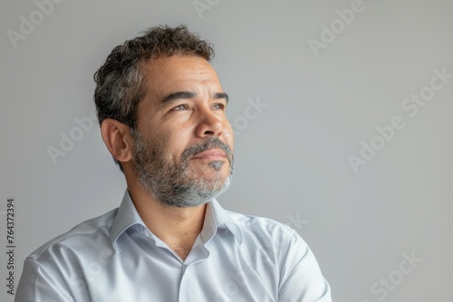 A man with a beard and gray hair is looking at the camera