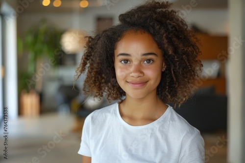 A young woman with curly hair is smiling for the camera © top images