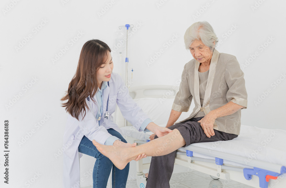Obraz premium Asian female doctor holding leg of old stroke patient, they training to rehab muscle in hospital, Knee Replacement, Osteoarthritis of the Knee, elderly rehabilitation clinic