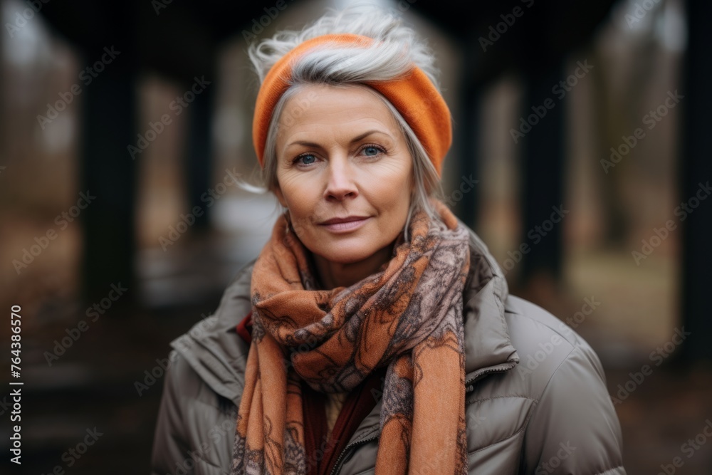 Portrait of a beautiful middle aged woman in an orange hat and scarf