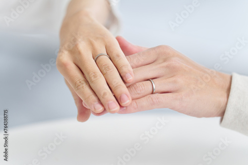 手を重ねて結婚指輪を見せる夫婦