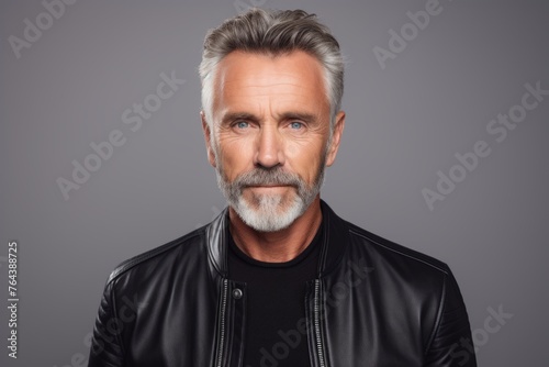 Handsome mature man in black leather jacket and gray beard.