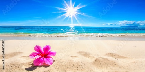 A summer sunburst over tranquil sea with pink frangipani on sandy shore. © Dougie C
