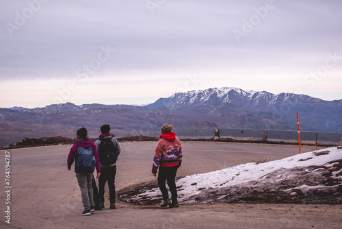 Joyous winter friendship moments  group of people with mountain gear hiking in the snow in the hilltop