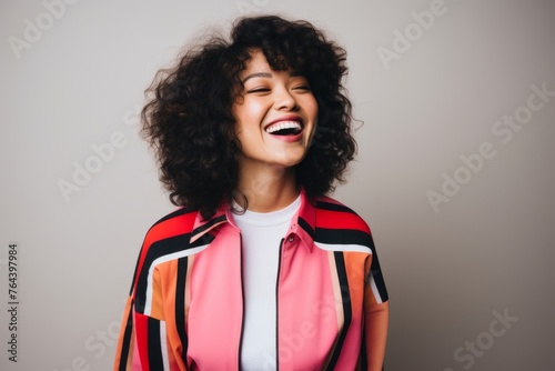 excited african american woman in stylish jacket on grey background