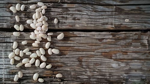 White beans arranged in large groups on a weathered wooden background.
