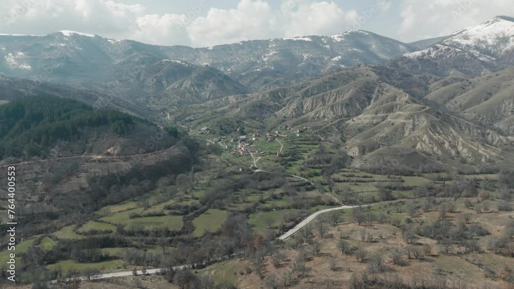 A drone shot of forest mountains with snow, warm weather, little village, rotating flying above the dreamy hill, 4K video, European winter nature, scenic white clouds A drone shot of forest mountains with snow, warm weather, little village, rotating flying above the dreamy hill, 4K video, European winter nature, scenic white clouds