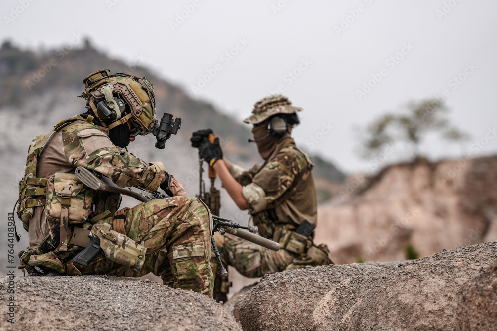 Soldiers in camo gear during a tactical operation with binoculars and rifles on a rocky terrain, showcasing military precision and readiness. Soldiers in camo gear during a tactical operation with binoculars and rifles on a rocky terrain, showcasing military precision and readiness.