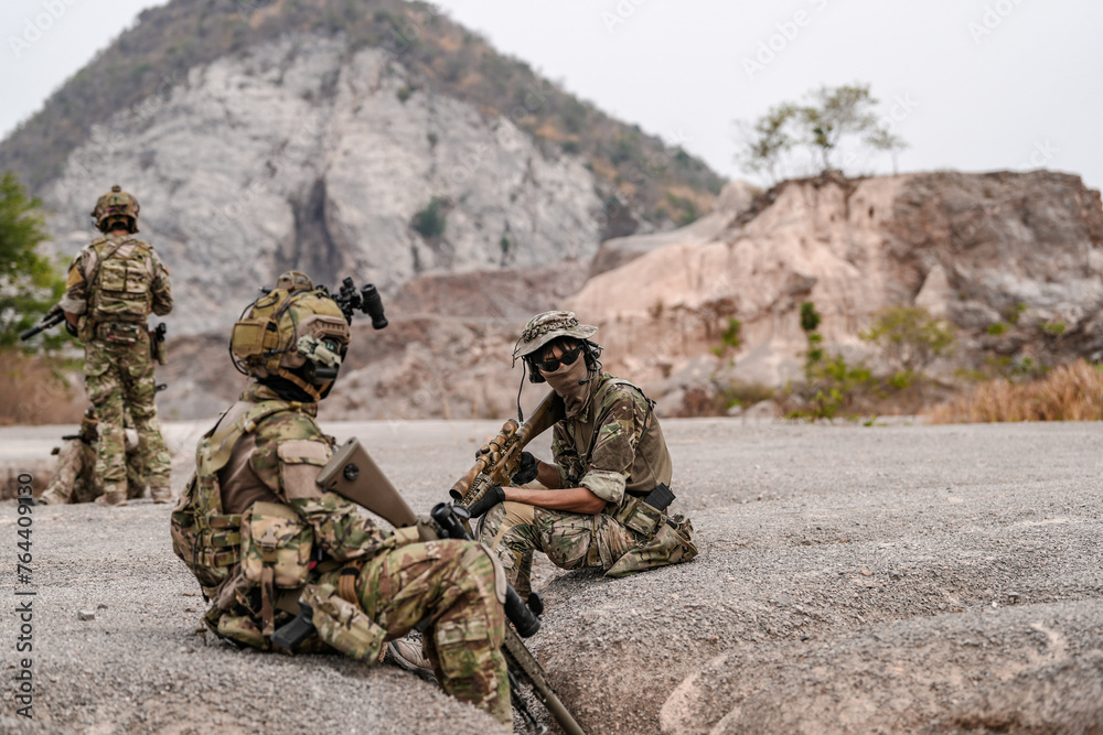 Soldiers in camo gear during a tactical operation with binoculars and rifles on a rocky terrain, showcasing military precision and readiness. Soldiers in camo gear during a tactical operation with binoculars and rifles on a rocky terrain, showcasing military precision and readiness.