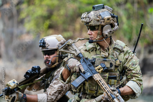 Tableau sur toile Soldiers in tactical gear aiming guns during a military exercise, showcasing teamwork and defense strategies