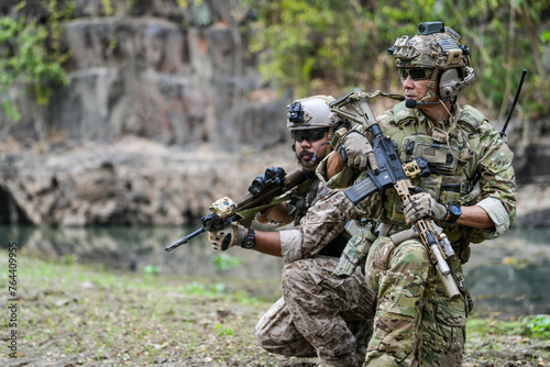 Soldiers in tactical gear aiming guns during a military exercise  showcasing teamwork and defense strategies.