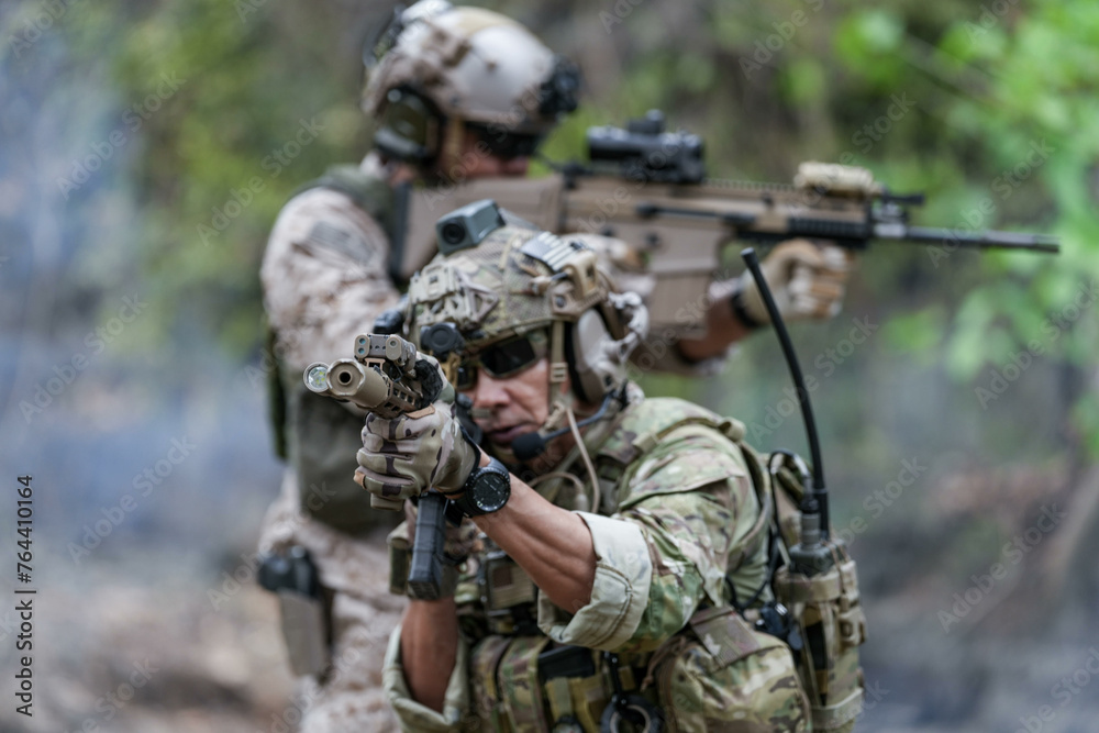 Soldiers in tactical gear aiming guns during a military exercise, showcasing teamwork and defense strategies. Soldiers in tactical gear aiming guns during a military exercise, showcasing teamwork and defense strategies.