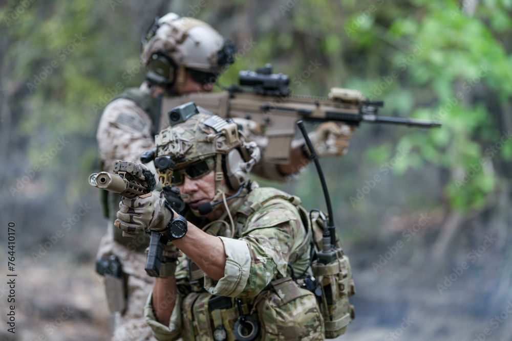 Soldiers in tactical gear aiming guns during a military exercise, showcasing teamwork and defense strategies. Soldiers in tactical gear aiming guns during a military exercise, showcasing teamwork and defense strategies.