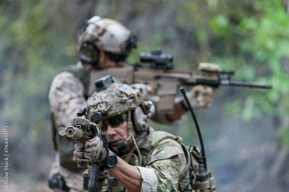 Soldiers in tactical gear aiming guns during a military exercise, showcasing teamwork and defense strategies. Soldiers in tactical gear aiming guns during a military exercise, showcasing teamwork and defense strategies.