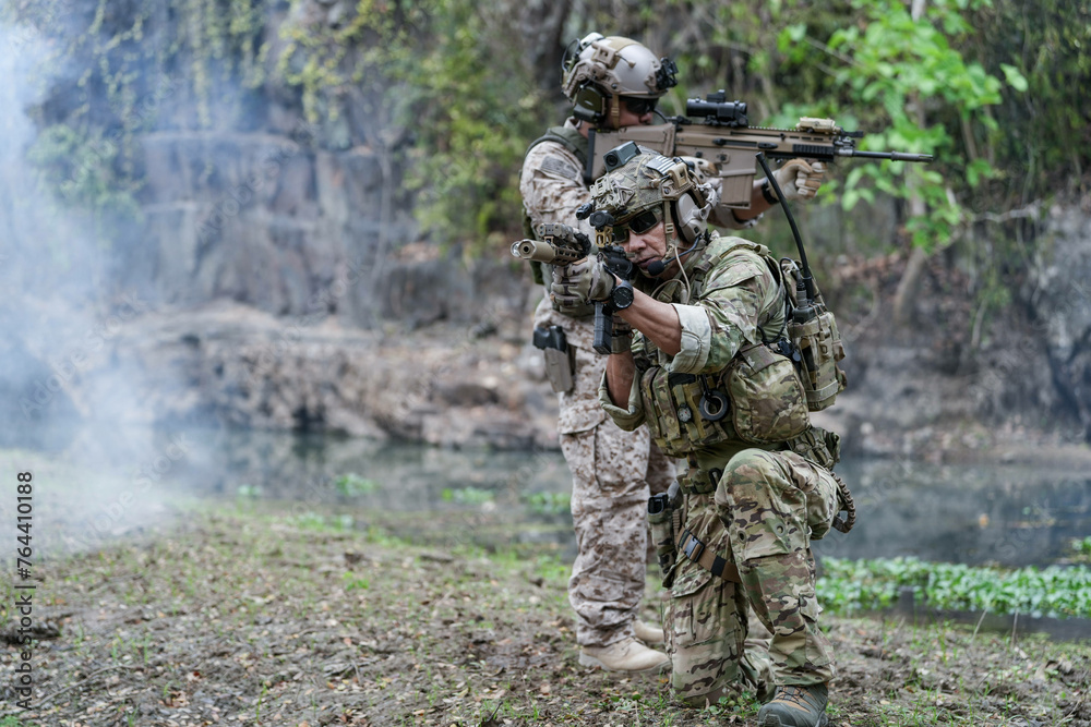 Soldiers in tactical gear aiming guns during a military exercise, showcasing teamwork and defense strategies.