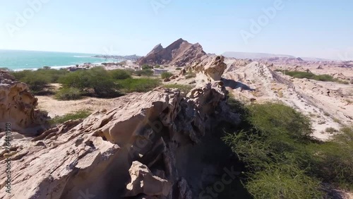 fly over sea landscape rock cliff wind erosion sand formation in coastal rural countryside wide panoramic view of ocean in day time in gulf surfin paddle board diving adventure in Qatar UAE resort photo