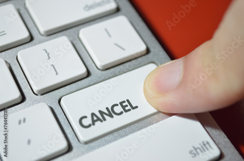 Cancel, illustrated by finger pressing cancel key down. photo