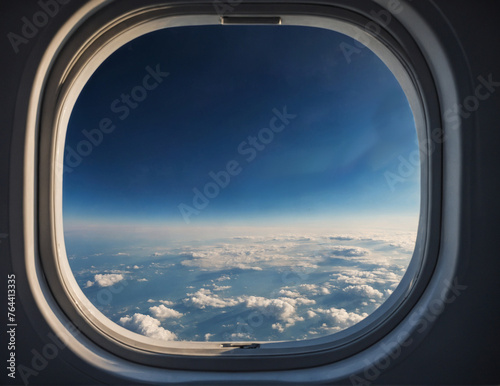 Airplane window with clouds and sky.