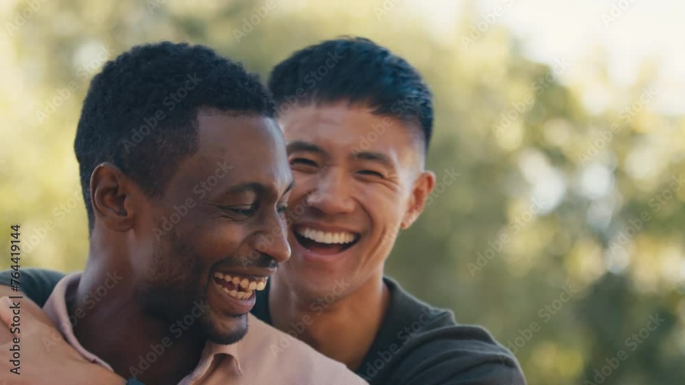Close up portrait of same sex male couple or friends standing outside in beautiful countryside laughing and smiling as they hug and look at camera - shot in slow motion Close up portrait of same sex male couple or friends standing outside in beautiful countryside laughing and smiling as they hug and look at camera - shot in slow motion