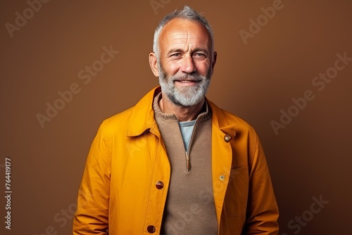 Portrait of a handsome senior man in a yellow jacket. Studio shot.