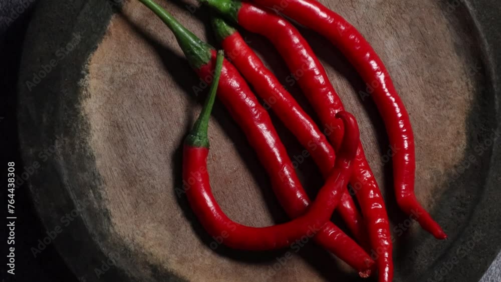 red chilli on the wooden plate with rotating background. Top view concept. red chilli on the wooden plate with rotating background. Top view concept.