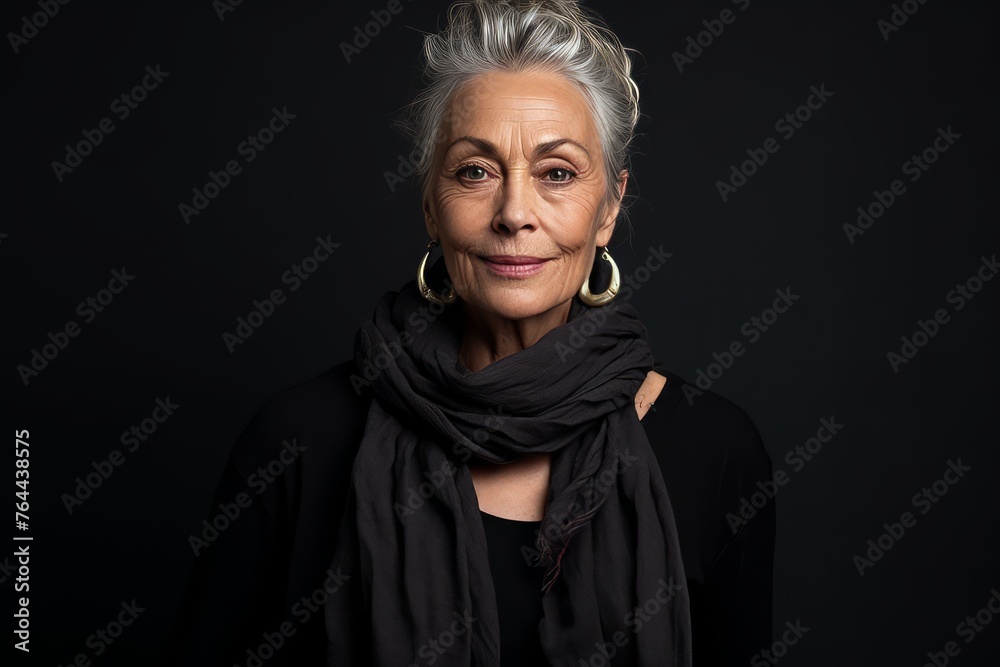 Portrait of a beautiful senior woman with grey hair and scarf on a black background Portrait of a beautiful senior woman with grey hair and scarf on a black background