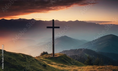 black silhouette of mountains alps, hills, forest and cross / summit cross, in the evening during the sunset, with orange colored sky © Andrey