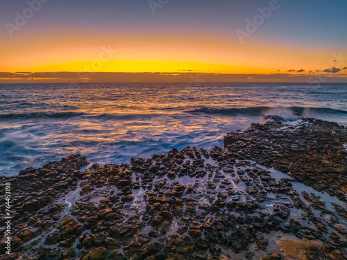 Sunrise over the sea and rock platform © Merrillie