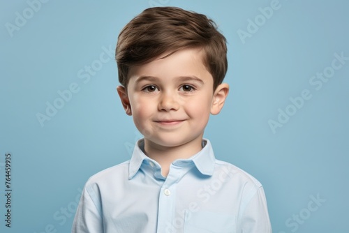 Portrait of a cute little boy in a blue shirt on a blue background