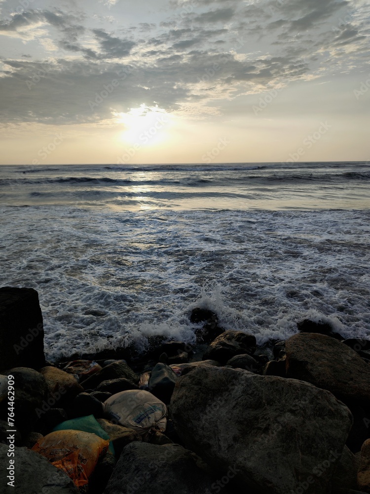 Playa con atardecer, playa soleada, olas del mar, nubes en el cielo