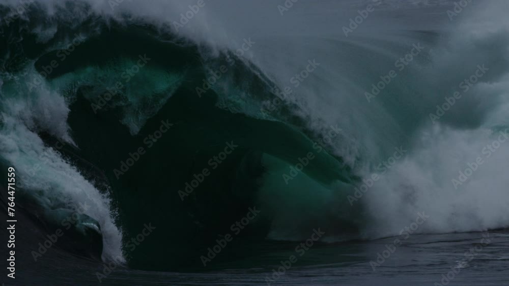 Heavy winter swell barrel crashes collapsing on tube with whitewash spray misting in slow motion